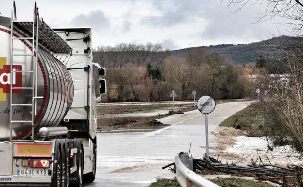 Imagen. Un camión circula por la anegada carretera de Becerril del Carpio a Mave. 