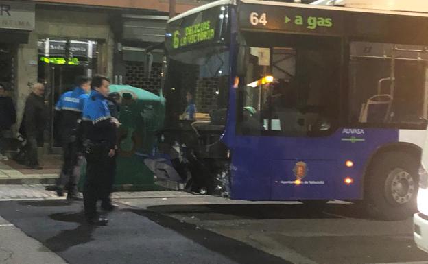 Dos agentes junto al autobús contra el que se ha chocado el turismo.