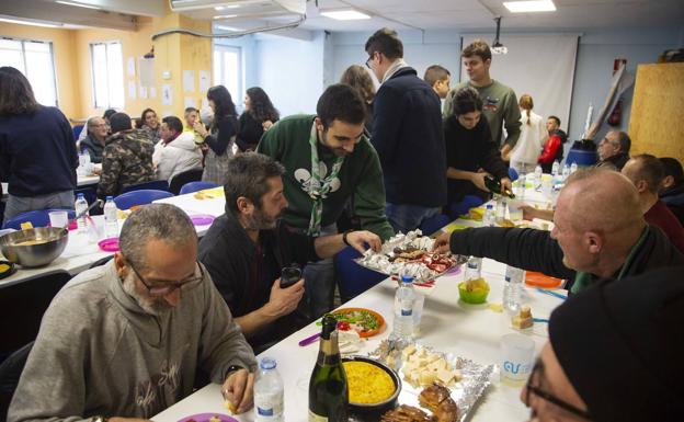 Varios jóvenes ofrecen dulces navideños a los asistentes a la comida organizada por el Consejo de la Juventud. 