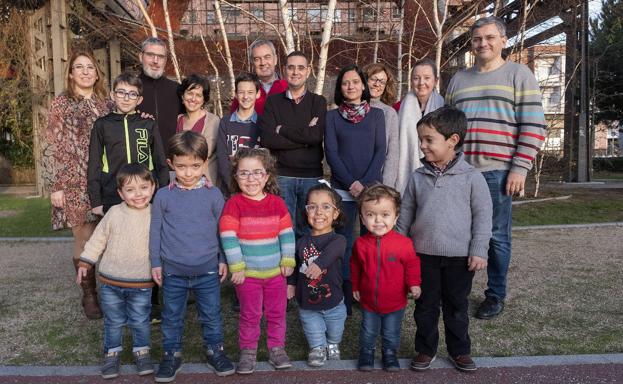 Los niños y sus padres posan en los jardines de Ariza.