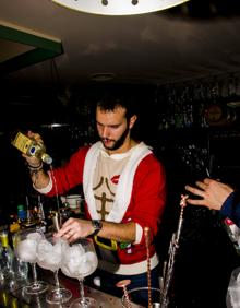 Imagen secundaria 2 - Arriba, venta de vino caliente, en el bar Y un Cuerno 2.1. Abajo, a la izquierda, tres clientes del Y un Cuerno disfrutan de la noche y a la derecha, Un camarero prepara una copa en el bar Mondo Lirondo.