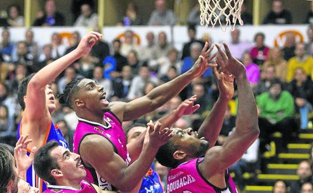 Bartley, Federico y Aboubacar, del Carramimbre, luchan por un balón bajo el aro. 