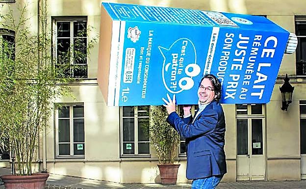 Nicolás Chabanne porta un cartón gigante de su marca de leche que se ha convertido en una de las más demandadas en Francia.