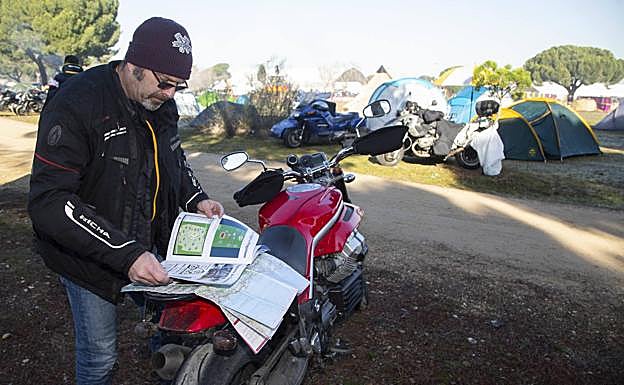 Consultando el programa de mano de la organización y con el mapa desplegado sobre la moto. 