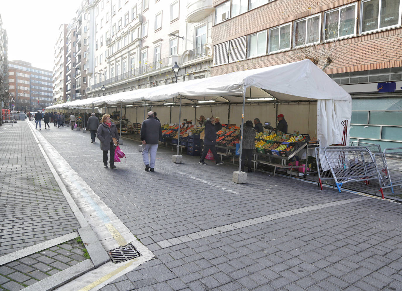 Los puestos del mercado de la Marquesina de la plaza de España se han trasladado hoy, y allí permanecerán durante las próximas cuatro semanas, a la calle Muro, donde se han habilitado carpas sobre el espacio de aparcamiento para vehículos más próximo a la plaza de Madrid.