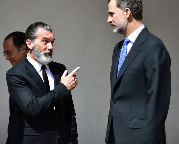 El actor Antonio Banderas, en traje negro con corbata y con barba poblada, charla con el rey Felipe VI en el premio Camino Real en 2017.