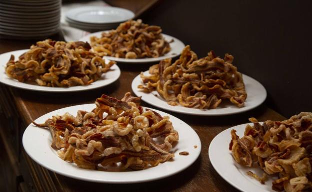 Imagen principal - Algunos de los 22 platos de la matanza: torreznos del alma, cochinillo asado y morro de cerdo. 