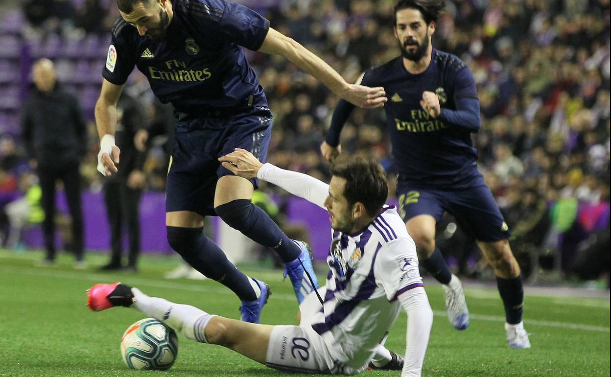 Benzema se lleva el balón ante Kiko Olivas e Isco. 