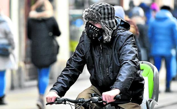 Un ciclista circula en carretera con mascarilla.