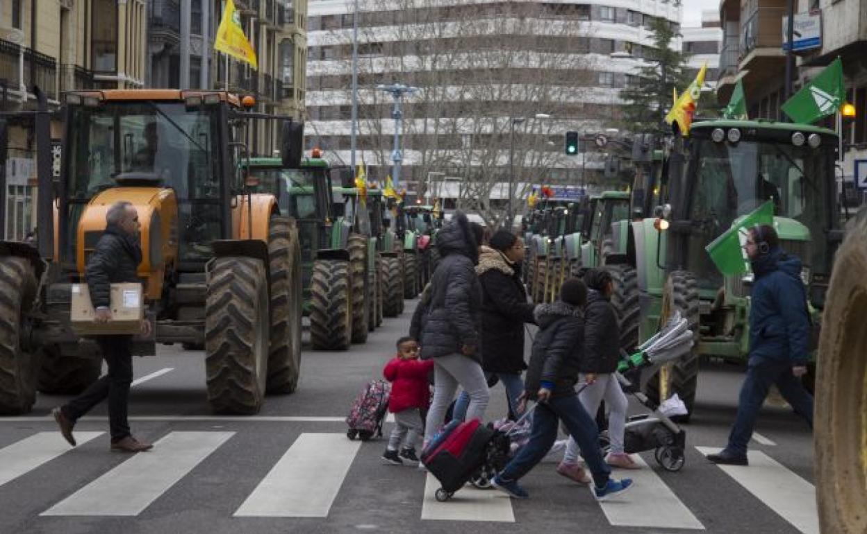 Peatones cruzan la calle entre la tractorada en el centro de Zamora. 