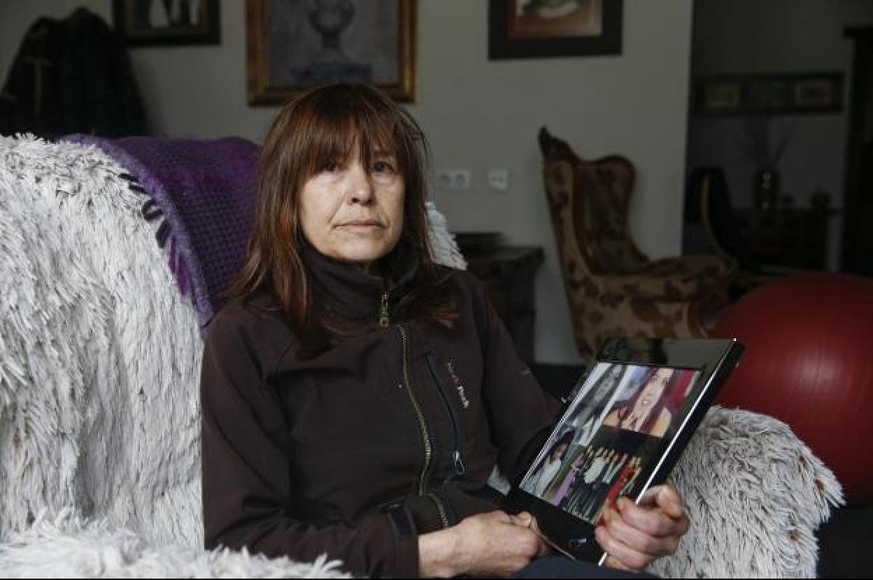 Julia Fernández, madre de Sheila Barrero, en el salón de su casa con un portafoto repleto de imágenes de su hija. 