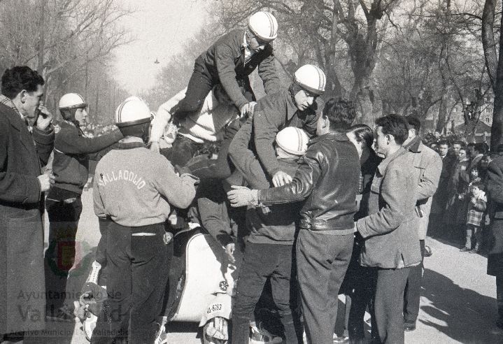 El domingo 19 de enero de 1958, veinte mil personas presenciaron la prueba que se celebró en el paseo alto de las Moreras | La prueba consistió en formar una barrera humana sobre una moto Vespa con diez y siete hombres abordo y así recorrer más de quinientos metros, batiendo el récord mundial que los ingleses habían establecido días antes | La 'Vespa' era conducida por Virgilio Collantes, el gran héroe del día