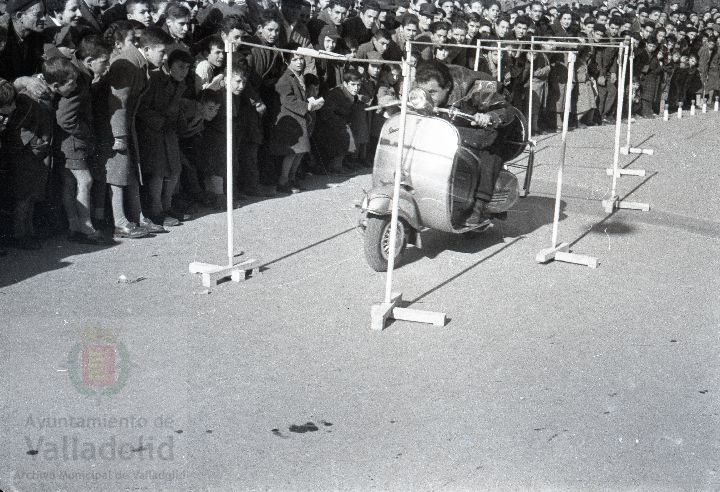 El domingo 19 de enero de 1958, veinte mil personas presenciaron la prueba que se celebró en el paseo alto de las Moreras | La prueba consistió en formar una barrera humana sobre una moto Vespa con diez y siete hombres abordo y así recorrer más de quinientos metros, batiendo el récord mundial que los ingleses habían establecido días antes | La 'Vespa' era conducida por Virgilio Collantes, el gran héroe del día