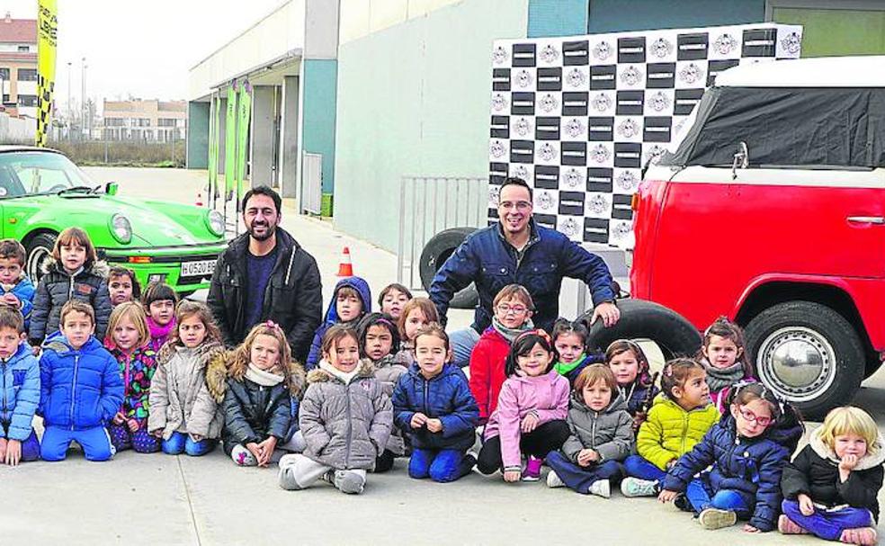 Los alumnos de 2º de Infantil del colegio público El Peral posan con sus tutores y José Alberto Lorenzo delante de los vehículos, el circuito y el podio.