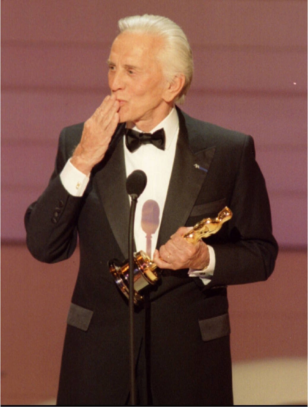 Kirk Douglas lanzando un beso con el Oscar conseguido a su trayectoria profesional en 1996.