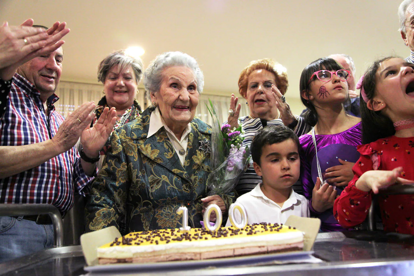 Doña Flora sopla las velas, rodeada por su familia. 