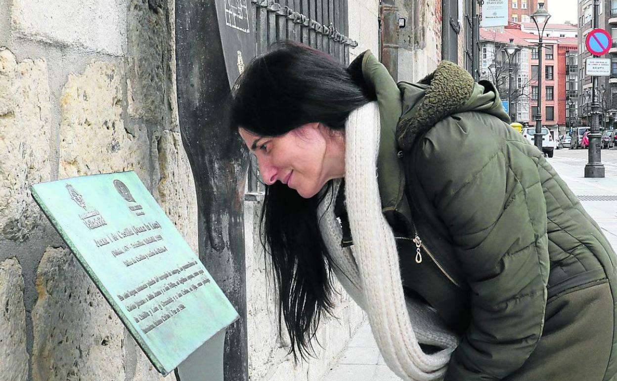 Una mujer lee la placa dedicada a Isabel I de Castilla, ubicada en el Palacio de Pimentel. 