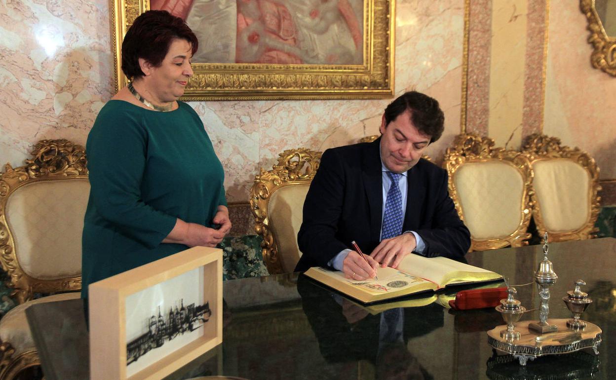 El presidente de la Junta firma en el libro de honor del Ayuntamiento en presencia de la alcaldesa de Segovia. 