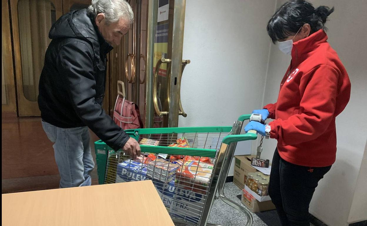 Una voluntaria de Cruz Roja distribuye comida.