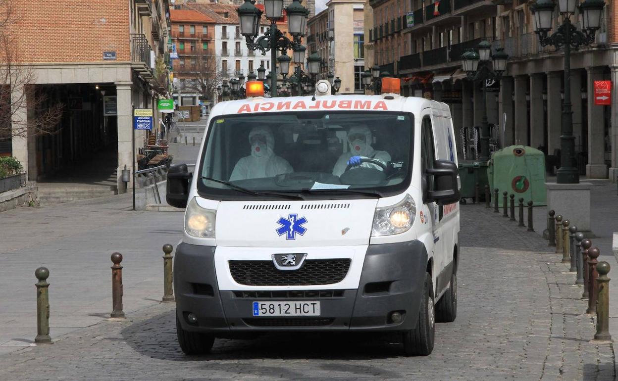 Dos sanitarios viajan en una ambulancia por el centro de Segovia con el buzo de protección puesto. 