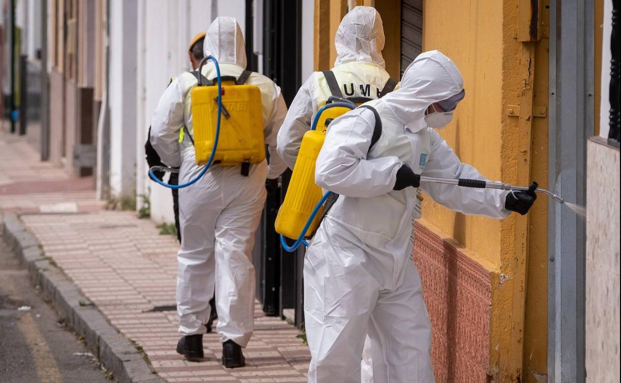 Efectivos de la UME llevan a cabo la desinfección de una calle de la localidad onubense de Lucerna del Puerto. 