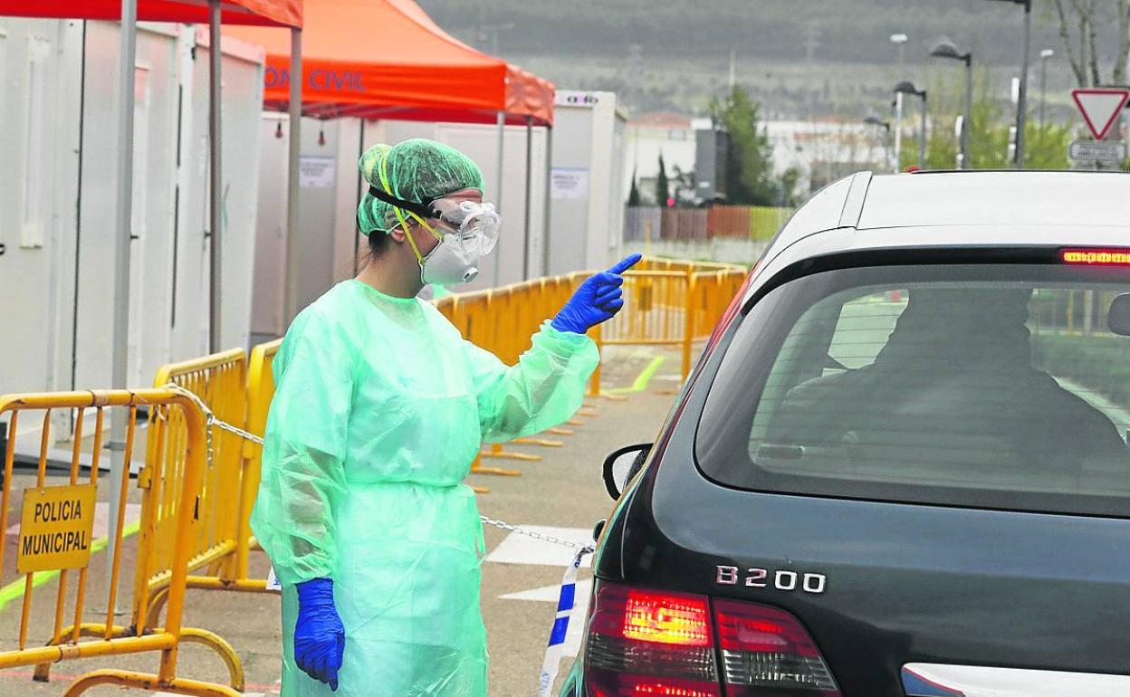 Personal del hospital de campaña del Río Hortega da instrucciones a un paciente que llega en coche.