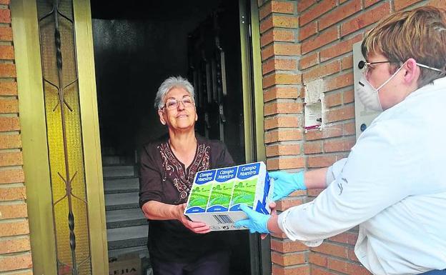 Yolanda Martín entrega leche a una vecina de Cogeces del Monte.