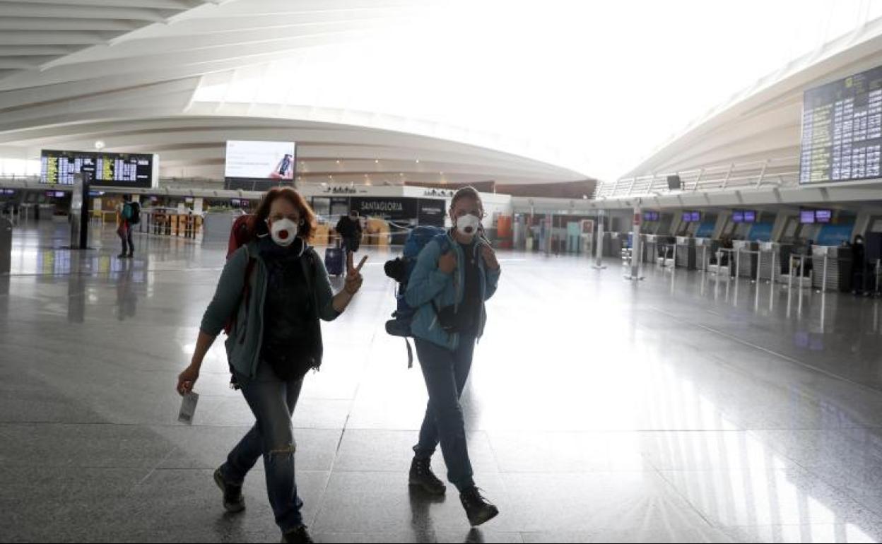 Turistas con mascarilla en el aeropuerto de Bilbao.