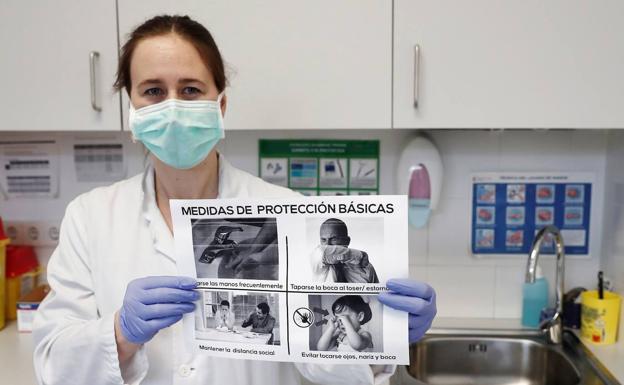 Una enfermera muestra una cartel con las medidas de protección básicas ante el coronavirus.