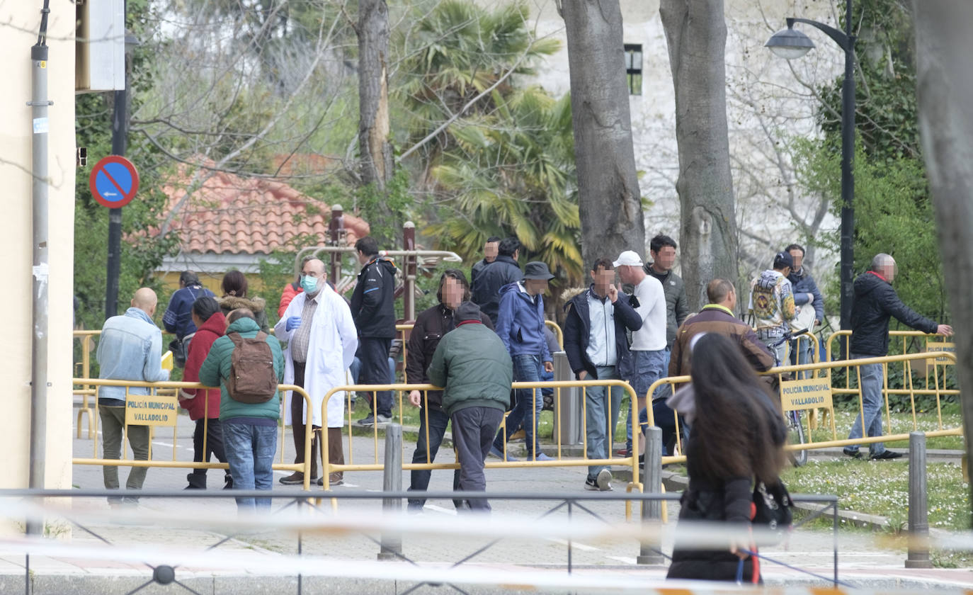 Varias personas, a las puertas del centro temporal de atención a los sin techo, esperan al reparto diario de comida. 