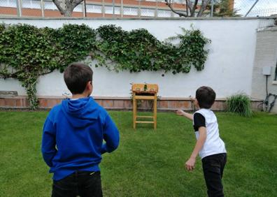 Imagen secundaria 1 - Ana Chamorro y su hijo Rubén, con el mural pintado en el patio de su casa en Girón. Debajo, Miguel y Gonzalo juegan a al rana en el jardín, y Ana Rojo cuida sus plantas. 