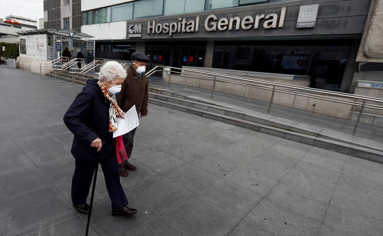 Una pareja de ancianos ante un hospital madrileño.