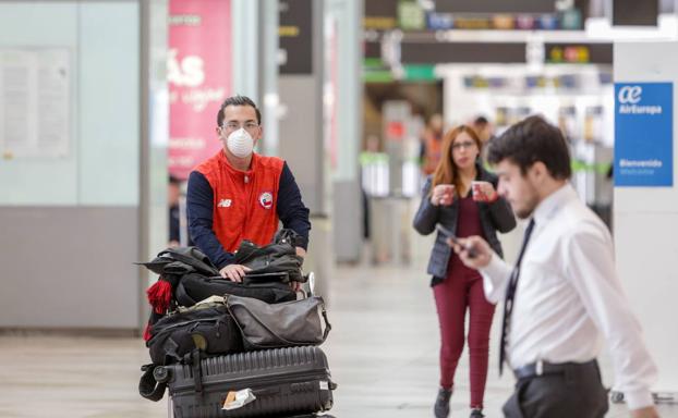 Pasajeros y trabajadores en el aeropuerto Adolfo Suarez-Madrid Barajas.