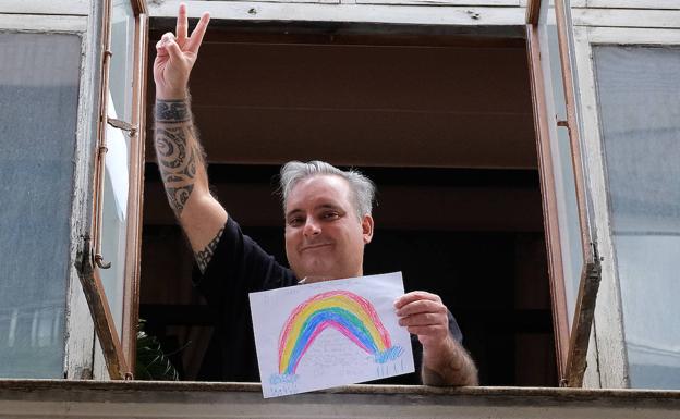 Marcos Esteban, ya asomado a la ventana de su domicilio en Valladolid con un dibujo de su hija. 