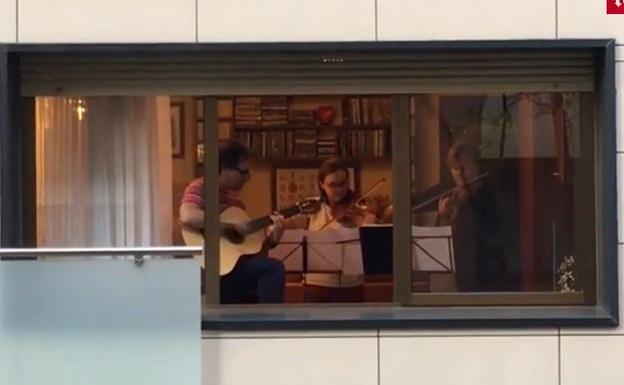 Una familia de violinistas toca 'Resistiré' desde la ventana de su céntrico domicilio en Valladolid