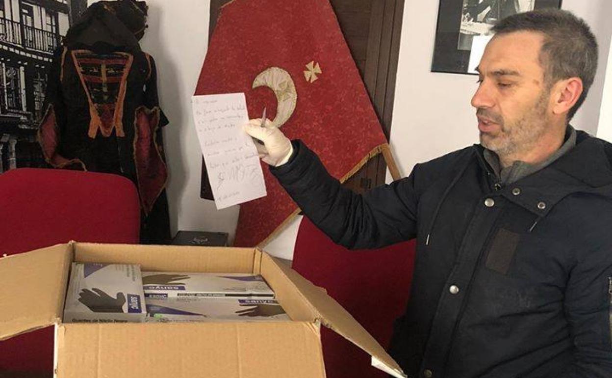 El alcalde muestra la caja con todo el material recibido. 