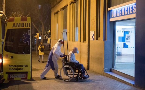 Un sanitario traslada a una persona a las urgencias de un hospital de Barcelona.