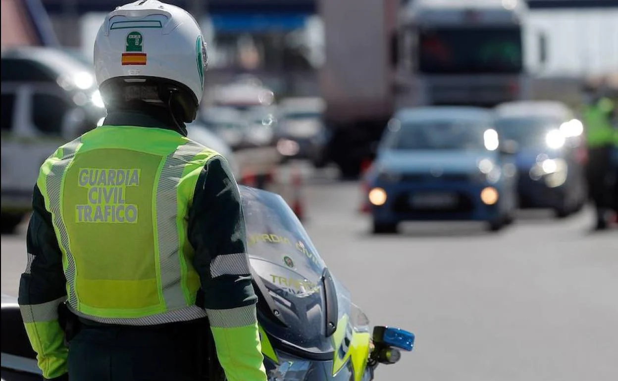 Un Guardia Civil junto a su moto durante un control. 