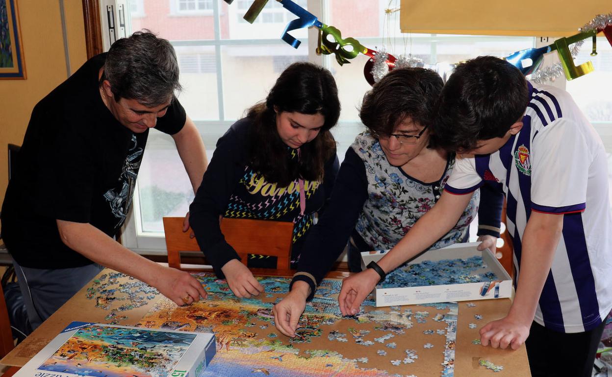 Carlos, Alba, Fresia y Jorge completan un puzle en su casa. 