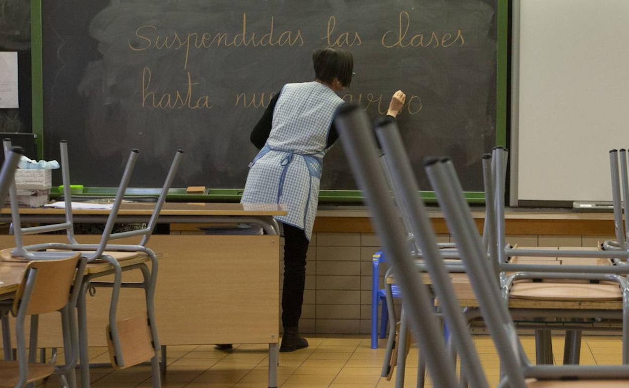 Una profesora de Primaria escribe «Suspendidas las clases hasta nuevo aviso» en el encerado el pasado 13 de marzo. 