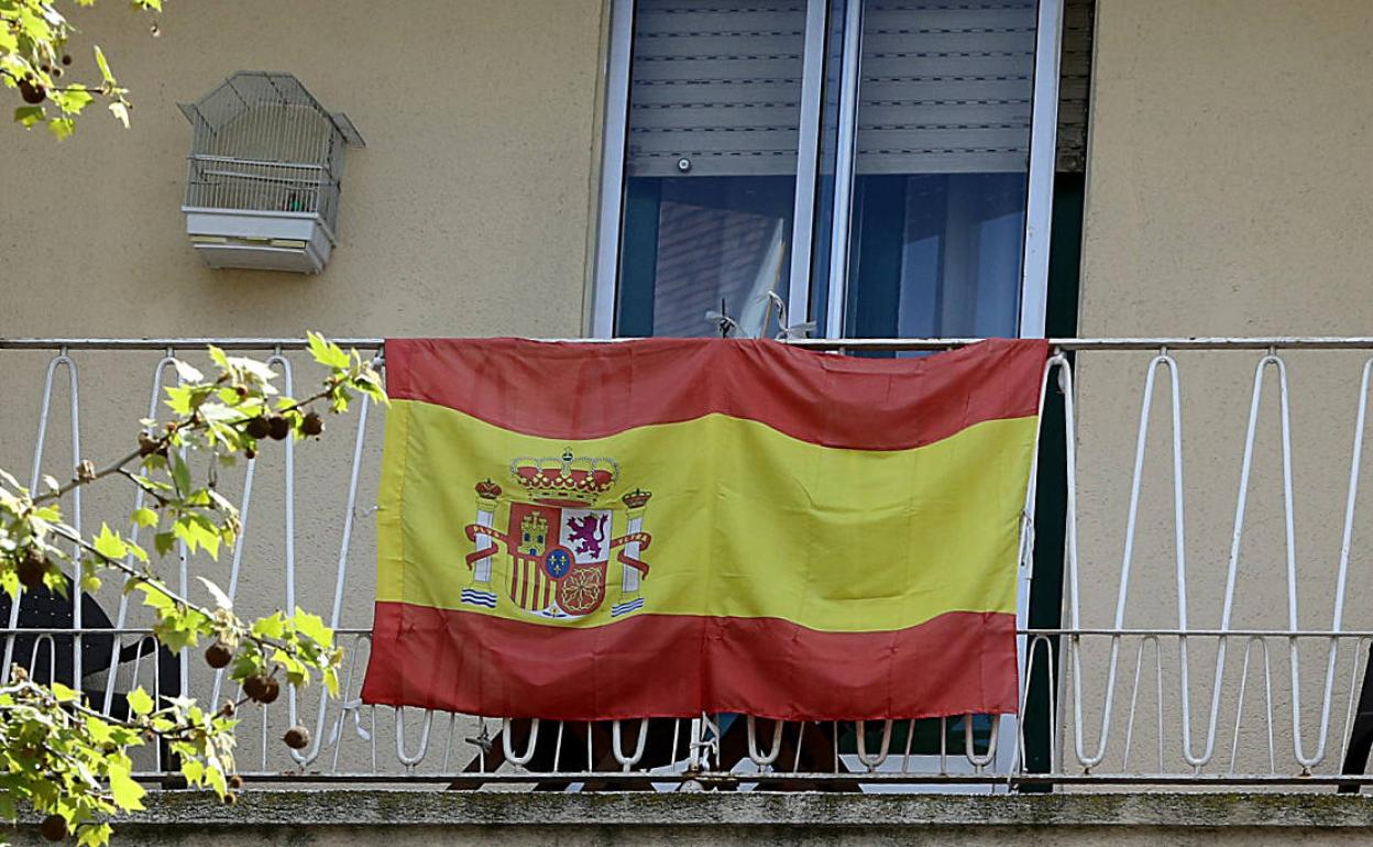 Un balcón con la bandera de España.