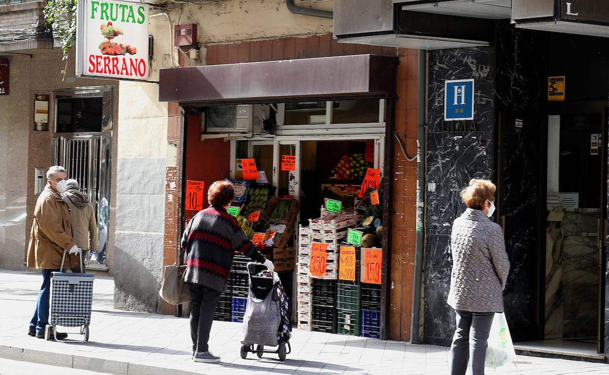 Cola para comprar frente a una frutería de Valladolid. 