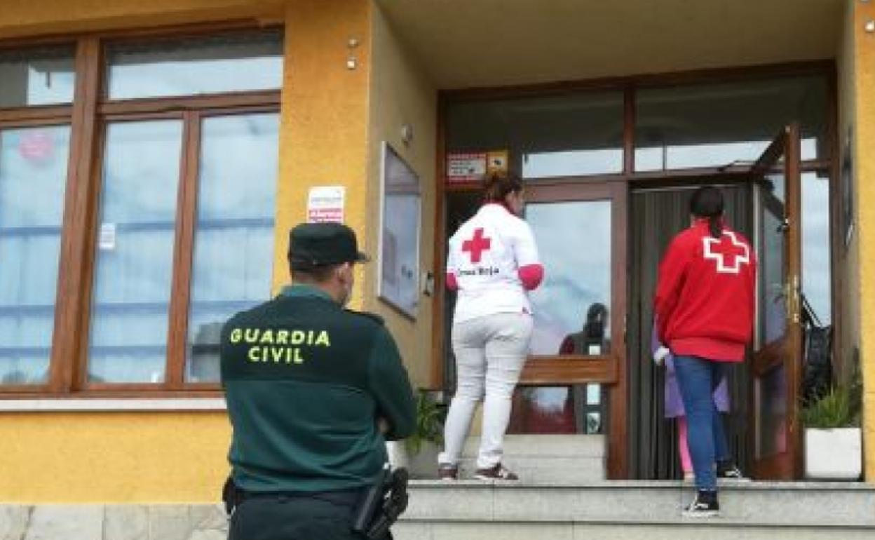 Un agente de la Guardia Civil y personal de Cruz Roja, a las puertas del club de alterne. 