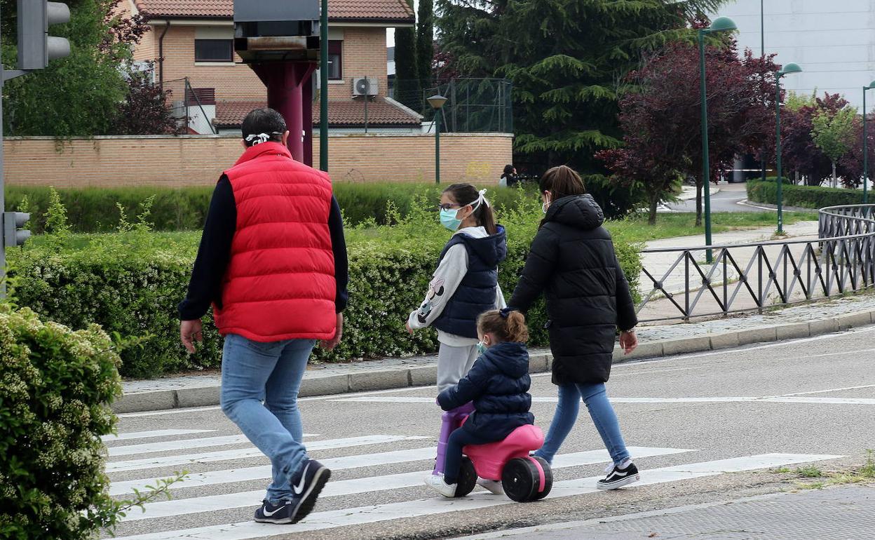 Niños acompañados de sus padres, en el primer día de permiso de paseos de una hora.