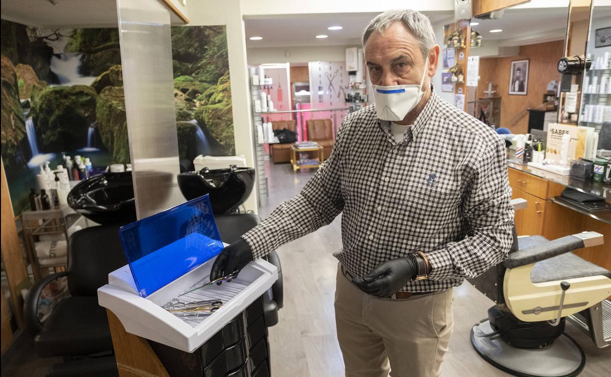 Mariano Castaño, con la máquina que ha adquirido para desinfectar los útiles que emplea en su peluquería.