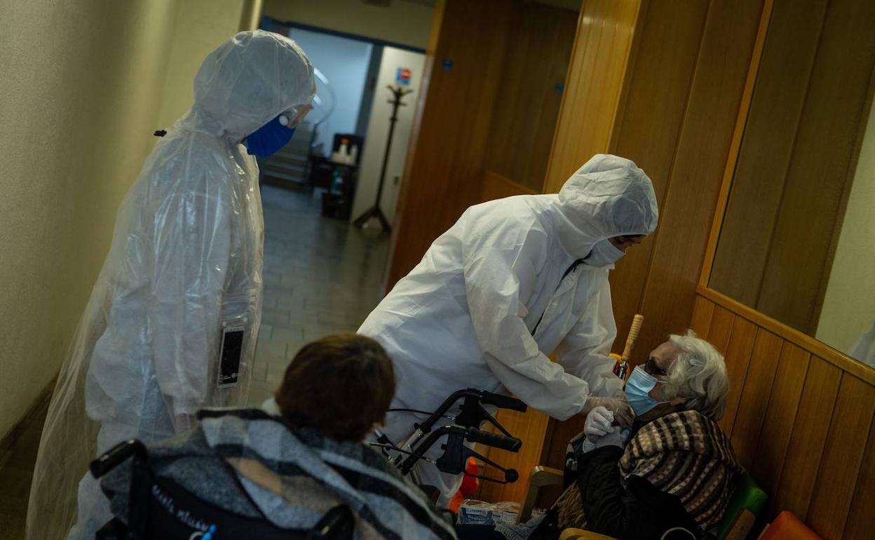 Personal de una residencia atiende a una anciana.