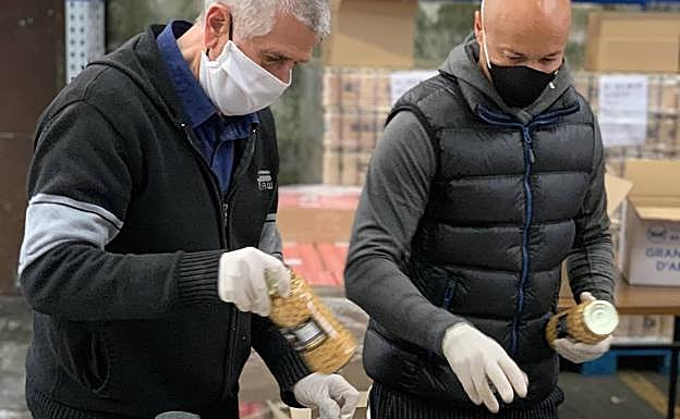 Dos voluntarios seleccionan alimentos.