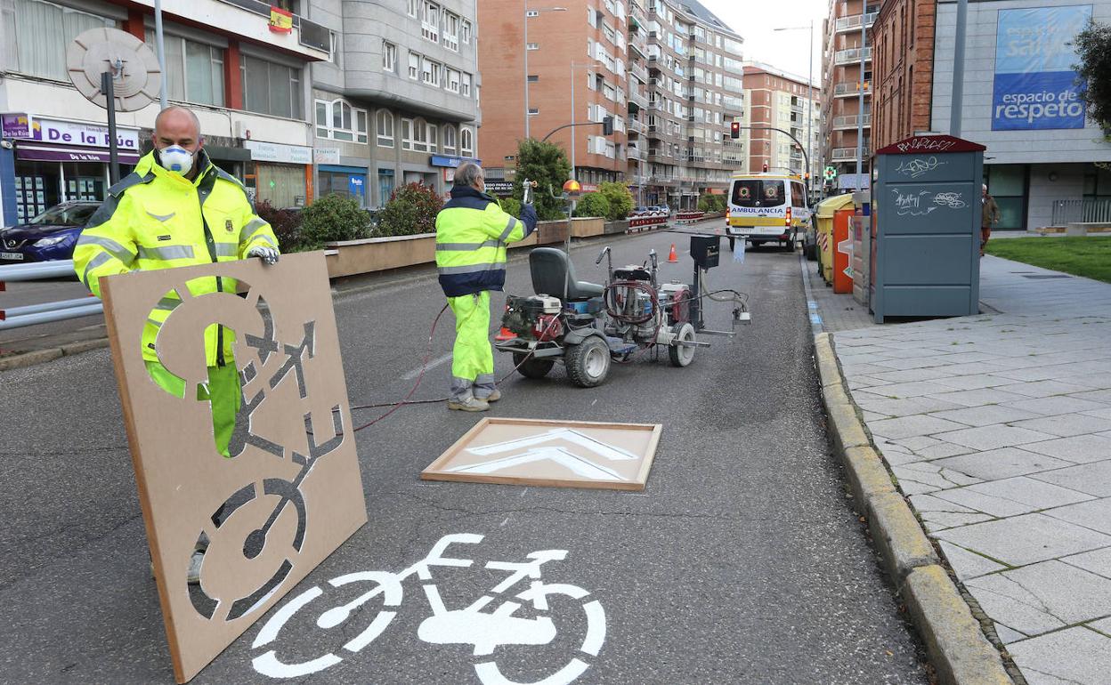 Los operarios municipales pintan la señalización en la avenida Modesto Lafuente.