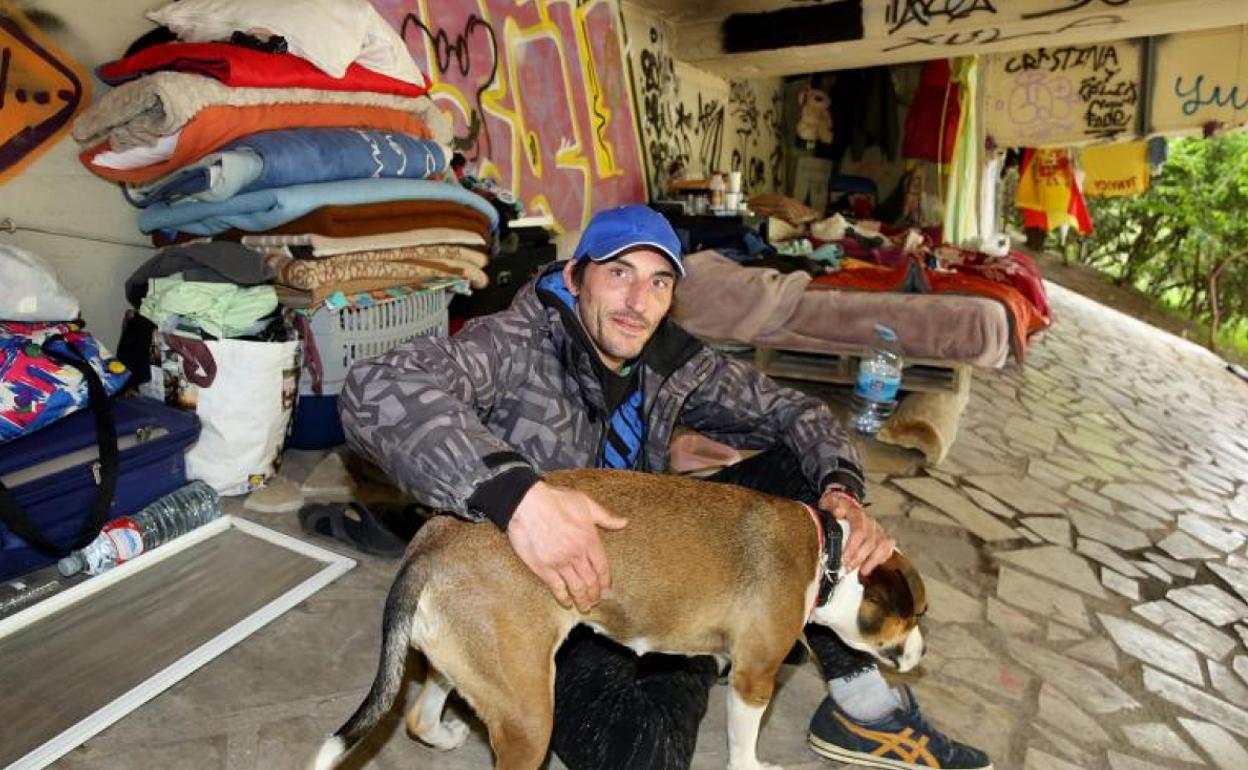 Félix, junto a su perra, en el 'hogar' que comparte bajo el puente de Isabel la Católica.