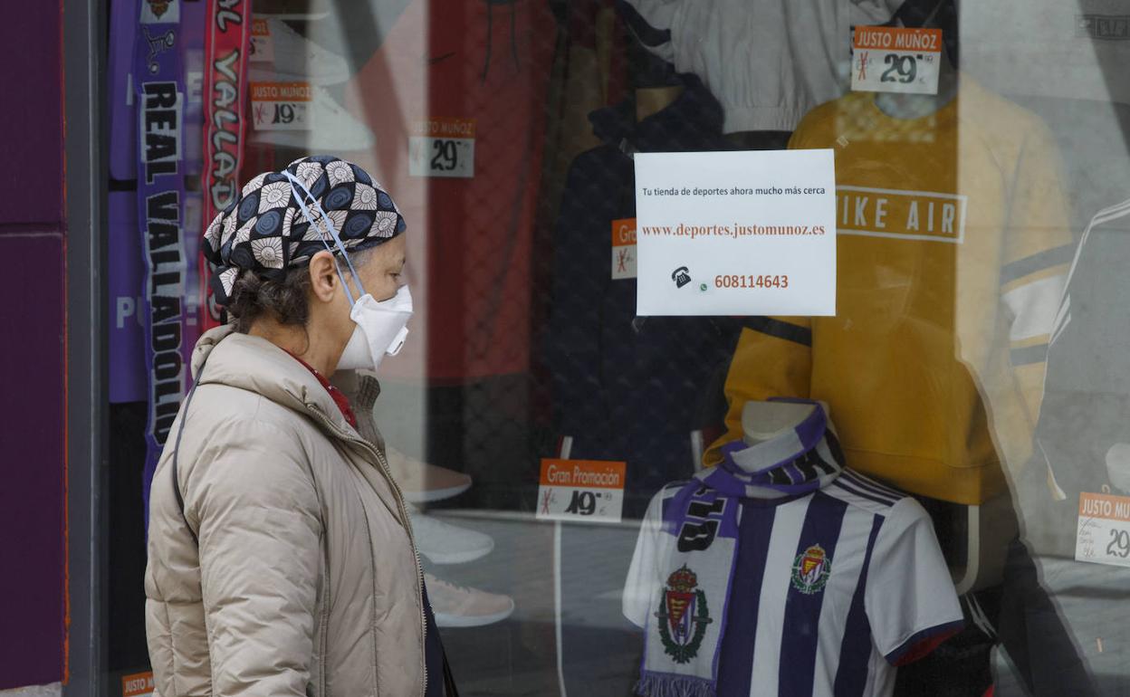 Una mujer observa el escaparate de la tienda Justo Muñoz, en Valladolid. 